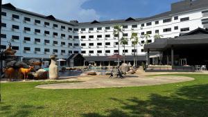 a large white building with a fountain in front of it at SWISS AVENUE HOTEL in Sungai Petani