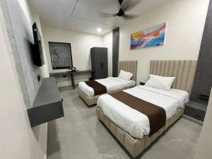 a hotel room with two beds and a flat screen tv at Hotel Ace Inn in Dr. Babasaheb Ambedkar International