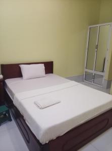 a bedroom with a large bed with white sheets at Pov Monique 2 in Stœ̆ng Trêng +9 photos