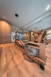 a woman sitting on a bench in a room at Zin Park alpine suites and SPA in San Candido