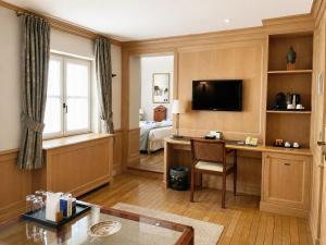 a hotel room with a desk and a bed at Hotel Le Dixseptième in Brussels