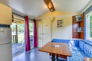 a kitchen with a blue couch and a table at Mon Gite En Camargue in Le Cailar