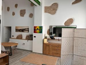a living room with a table and a tv on a wall at Villa Abril en el Porvenir in Seville