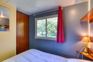 a bedroom with a bed and a window at Mon Gite En Camargue in Le Cailar