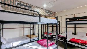 a dorm room with three bunk beds in it at KSHIPRA GUEST HOUSE in Ujjain