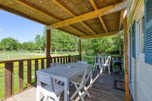 a wooden deck with a table and chairs on it at Mon Gite En Camargue in Le Cailar