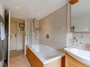 a bathroom with a tub and a sink at 4 Bed in Richmond oc-g0083 in Feetham +19 photos