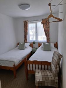 a room with two beds and a chair and a window at Barbican Paignton in Paignton