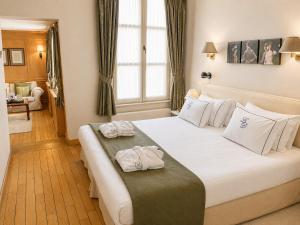 a bedroom with a large white bed with towels on it at Hotel Le Dixseptième in Brussels