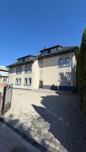 a large white building with a gate in front of it at DelMar in Klaipėda