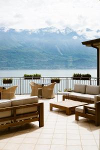 a patio with couches and a view of the mountains at Hotel Mercedes in Limone sul Garda