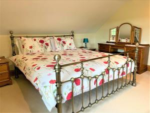a bedroom with a bed with a floral bedspread at 2 Bed in Liskeard oc-landc in Duloe