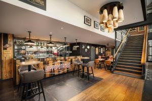 a restaurant with a bar and some tables and chairs at Moxy Paris La Villette in Paris