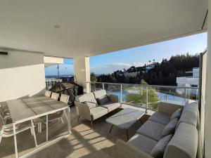 a balcony with a couch and chairs and a table at Vitta Nature Spa - 3 bedrooms in Mijas Costa