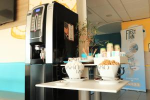 a coffee station with two cups on a table at First Inn Hotel Blois in Blois