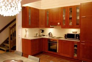 a kitchen with wooden cabinets and a microwave at Karhunvartija 11 Visit Levi in Sirkka