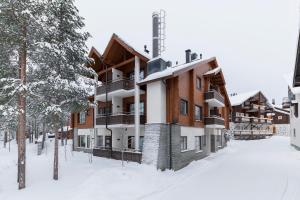 an apartment building in the snow with trees at Karhunvartija 11 Visit Levi in Sirkka