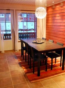 a dining room table with chairs and a chandelier at Karhunvartija 11 Visit Levi in Sirkka