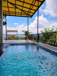 a swimming pool with a view of the ocean at Moya Villa & Resto in Cihideung