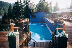 a swimming pool with a deck and a house at Gasthaus & Spa Bukovel in Bukovel