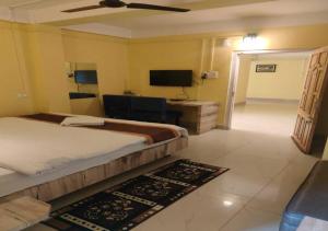 a hotel room with a bed and a television at Golf View Residency in Shillong