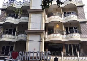 a tall building with balconies and a sign in front of it at Golf View Residency in Shillong
