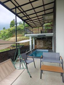 a patio with a hammock and a swimming pool at Moya Villa & Resto in Cihideung