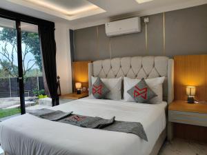 a bedroom with a large white bed with two pillows at Moya Villa & Resto in Cihideung +57 photos