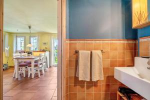 a bathroom with a sink and a kitchen with a table at Haus Bei Der Kirche in Oland