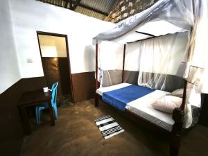 a bedroom with a canopy bed and a table at HOTSPOT inn - Malindi in Malindi +13 photos