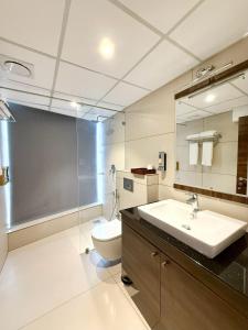 a bathroom with a sink and a toilet and a mirror at The Residence by Chakolas Pavilion in Cochin +16 photos