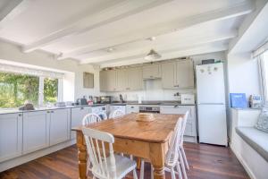 a kitchen with a wooden table and white appliances at 2 Caerau Isaf in Haverfordwest