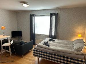 a bedroom with a bed and a couch and a window at Klintvägen 18 E 31 in Mariehamn