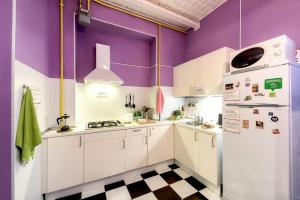 cocina con paredes moradas y nevera blanca en WonderHostel Central, en San Petersburgo
