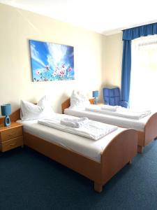 a room with two beds and a blue chair at Hotel Weldi in Győr +39 photos
