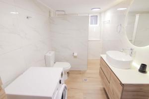 a white bathroom with a sink and a toilet at Thea Villa in Kokkinos Pirgos +40 photos