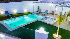 a swimming pool with two chairs and a palm tree at Thea Villa in Kokkinos Pirgos