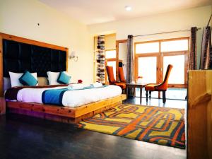 a bedroom with a bed and a table and chairs at Hotel DE Suzain-Leh in Leh