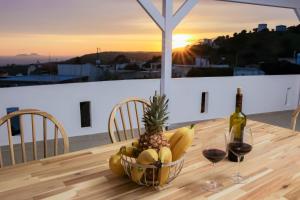 a bowl of fruit on a table with a bottle of wine at Thea Villa in Kokkinos Pirgos