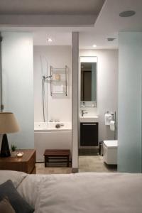 a bedroom with a bed and a bathroom with a sink at Seafront-Top Location-Close To Shops & Restaurants in St. Julianʼs +16 photos