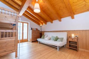 a living room with a couch and a wooden ceiling at El Feral - Mansarda in Selva di Cadore