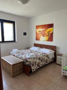 a bedroom with a bed and a painting on the wall at Dimora Dafne in Policoro