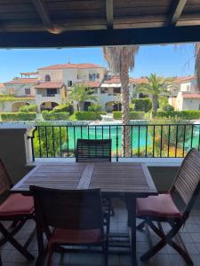 a table and chairs on a balcony with a view of a pool at Dimora Dafne in Policoro