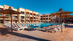 a swimming pool with lounge chairs and umbrellas at Club Paradisio in Marrakesh