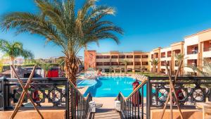 a resort with a palm tree and a swimming pool at Club Paradisio in Marrakesh