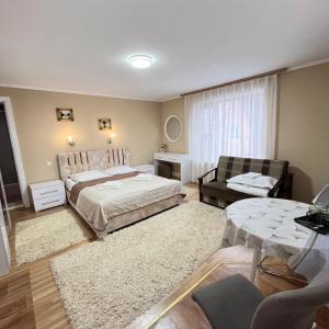 a bedroom with a bed and a couch and a table at Vivat in Solochyn +24 photos