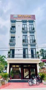 a building with a motorcycle parked in front of it at Mộc Hưng Homestay in Bắc Hà