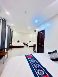 a bedroom with two beds and a room with three beds at Mộc Hưng Homestay in Bắc Hà