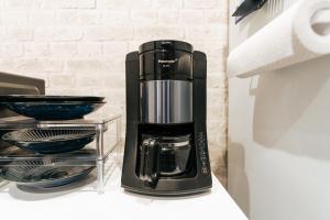 a coffee maker sitting on a counter next to a refrigerator at T-square旭大前I in Asahikawa