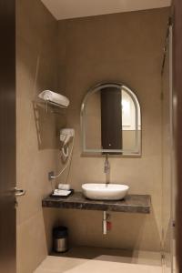 a bathroom with a sink and a mirror at Hotel Sachin in Chas +22 photos